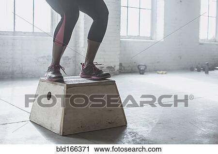 Athlete jumping on platform in gym View Large Photo Image Stock Image - Athlete jumping on platform in gym. Fotosearch