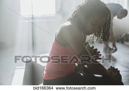 Picture - Athlete listening to mp3 player in gym. Fotosearch