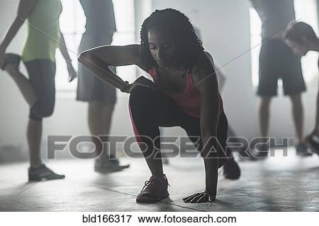 Stock Photo - Athlete stretching in gym. Fotosearch