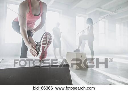 Athlete stretching in gym View Large Photo Image Stock Photograph - Athlete stretching in gym. Fotosearch