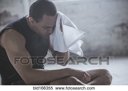 Stock Photography - Athlete wiping sweat with towel. Fotosearch