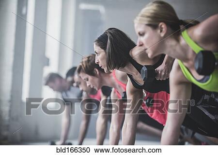 Athletes doing push-ups and lifting weights on floor View Large Photo Image Stock Image - Athletes doing push-ups and lifting weights on floor. Fotosearch