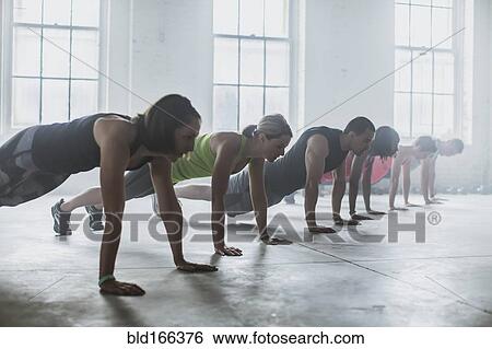 Stock Photograph - Athletes doing push-ups in gym. Fotosearch