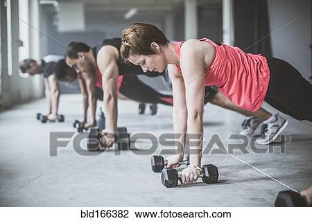 Athletes doing push-ups with dumbbells on floor View Large Photo Image Stock Image - Athletes doing push-ups with dumbbells on floor. Fotosearch