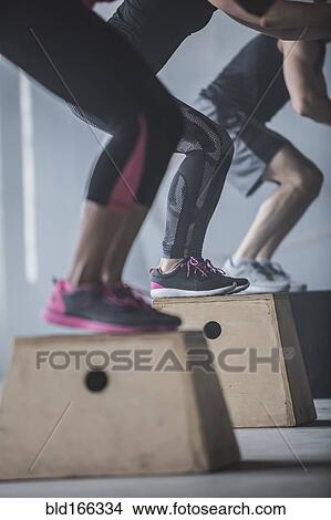 Picture - Athletes jumping on platforms in gym. Fotosearch