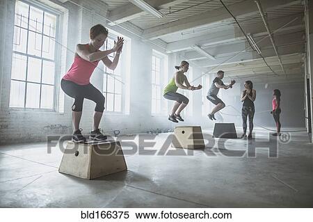 Athletes jumping on platforms in gym View Large Photo Image Stock Photography - Athletes jumping on platforms in gym. Fotosearch