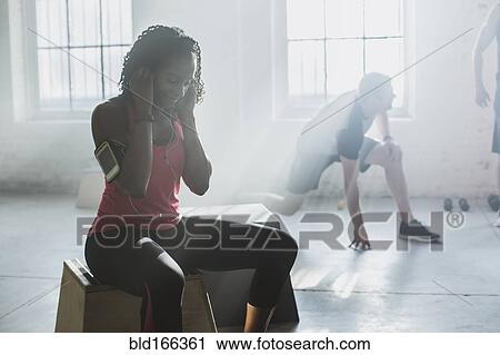 Stock Image - Athletes resting in gym. Fotosearch