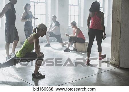 Stock Photo - Athletes stretching in gym. Fotosearch