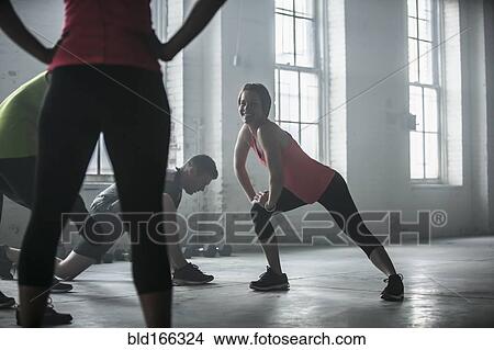 Picture - Athletes stretching legs in gym. Fotosearch