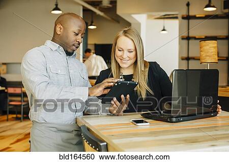 Barista and businesswoman using technology in cafe View Large Photo Image Stock Image - Barista and businesswoman using technology in cafe. Fotosearch