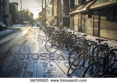Bicycles parked in snow on city sidewalk, New York, New York, United States View Large Photo Image Stock Image - Bicycles parked in snow on city sidewalk, New York, New York, United States. Fotosearch