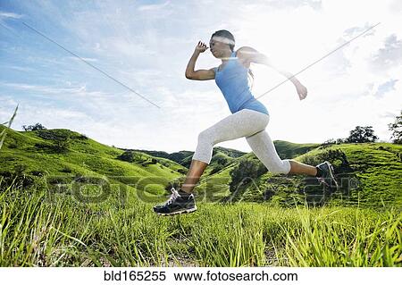 Stock Photography - Black athlete running on rural hilltop. Fotosearch