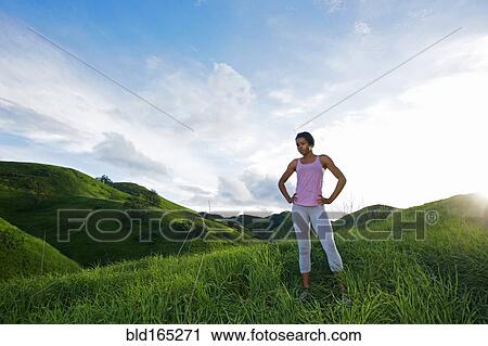 Stock Image - Black athlete standing on rural hillside. Fotosearch