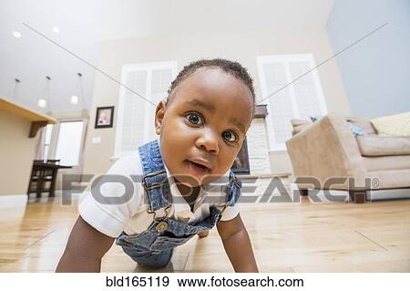 Black baby crawling on living room floor View Large Photo Image Stock Photo - Black baby crawling on living room floor. Fotosearch