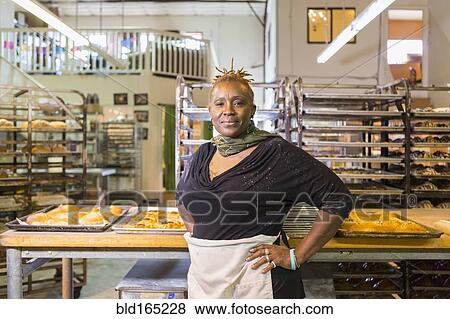 Stock Photo - Black baker standing in bakery kitchen. Fotosearch
