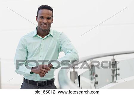 Black businessman leaning on railing View Large Photo Image Stock Image - Black businessman leaning on railing. Fotosearch