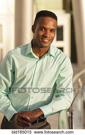 Black businessman leaning on railing View Large Photo Image Stock Photography - Black businessman leaning on railing. Fotosearch
