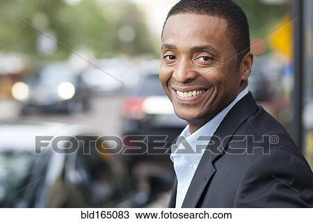 Black businessman smiling in city View Large Photo Image Stock Image - Black businessman smiling in city. Fotosearch