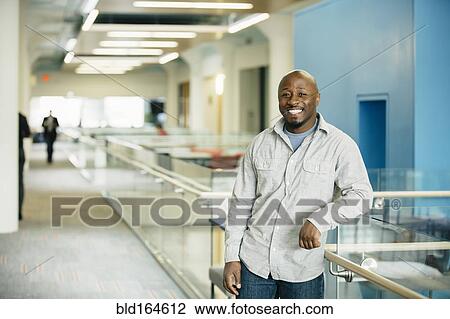 Black businessman smiling in office View Large Photo Image Stock Image - Black businessman smiling in office. Fotosearch