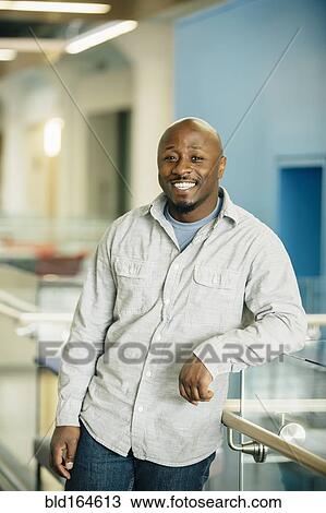 Stock Image - Black businessman smiling in office. Fotosearch