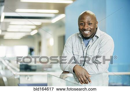 Stock Photo - Black businessman smiling in office. Fotosearch