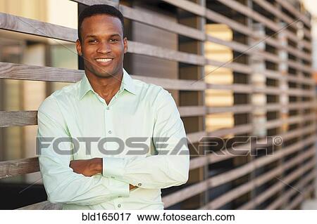 Stock Photo - Black businessman standing with arms crossed. Fotosearch
