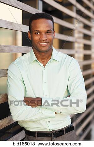 Stock Photo - Black businessman standing with arms crossed. Fotosearch