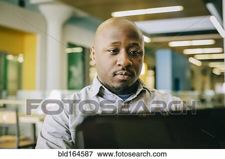 Black businessman using laptop in cafe View Large Photo Image Stock Photo - Black businessman using laptop in cafe. Fotosearch
