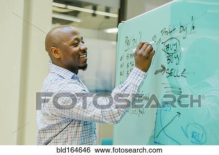 Stock Photograph - Black businessman writing on whiteboard. Fotosearch