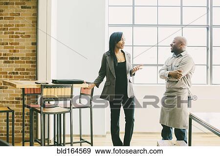Black businesswoman and waiter talking in cafe View Large Photo Image Stock Photo - Black businesswoman and waiter talking in cafe. Fotosearch