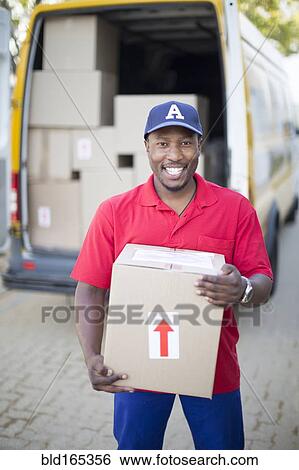 Stock Photograph - Black delivery man holding package. Fotosearch
