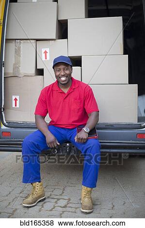 Black delivery man sitting with packages in van View Large Photo Image Stock Photo - Black delivery man sitting with packages in van. Fotosearch