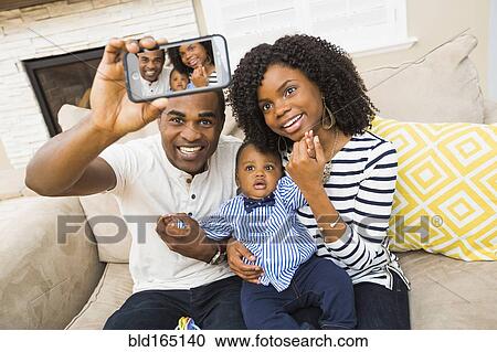 Black family taking selfie on sofa in living room View Large Photo Image Stock Image - Black family taking selfie on sofa in living room. Fotosearch