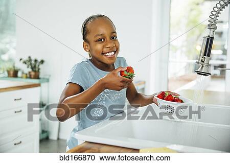 Black girl eating strawberries in kitchen View Large Photo Image Stock Image - Black girl eating strawberries in kitchen. Fotosearch