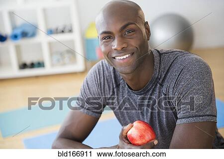 Black man eating apple in gym View Large Photo Image Stock Image - Black man eating apple in gym. Fotosearch