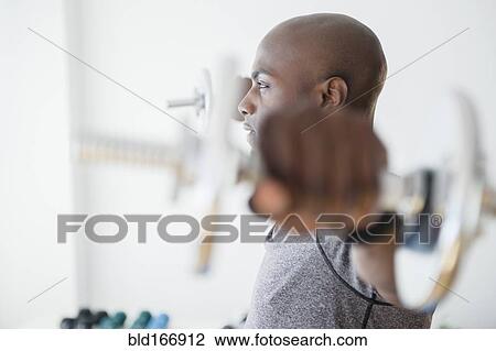 Black man lifting weights in gym View Large Photo Image Stock Image - Black man lifting weights in gym. Fotosearch