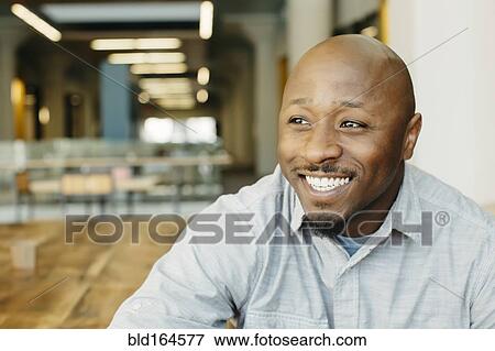 Stock Photo - Black man smiling in cafe. Fotosearch