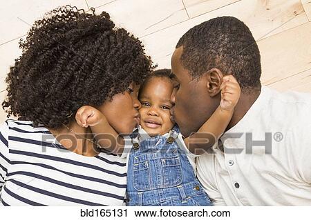Black mother and father kissing cheeks of baby son View Large Photo Image Stock Image - Black mother and father kissing cheeks of baby son. Fotosearch