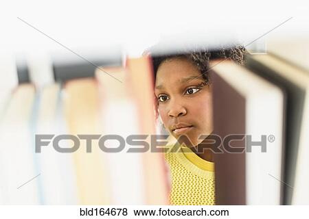 Black student choosing book from library shelf View Large Photo Image Stock Photo - Black student choosing book from library shelf. Fotosearch