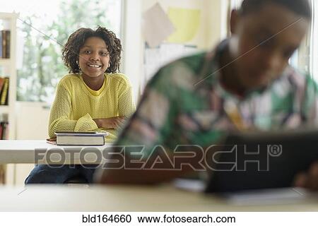 Stock Image - Black student smiling in classroom. Fotosearch