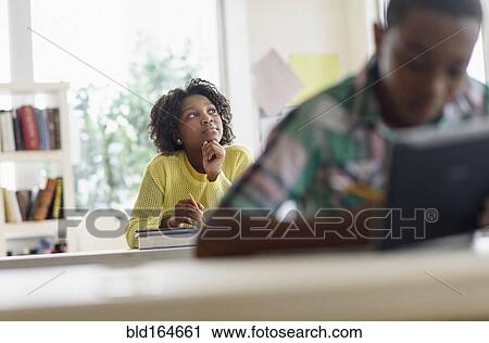 Stock Image - Black student thinking in classroom. Fotosearch