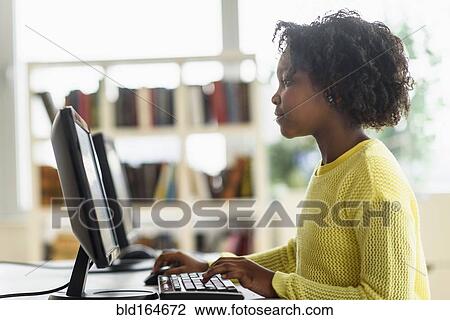 Stock Image - Black student using computer in classroom. Fotosearch