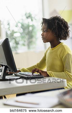 Stock Photography - Black student using computer in classroom. Fotosearch