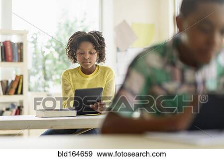 Black students using digital tablets in classroom View Large Photo Image Stock Photo - Black students using digital tablets in classroom. Fotosearch