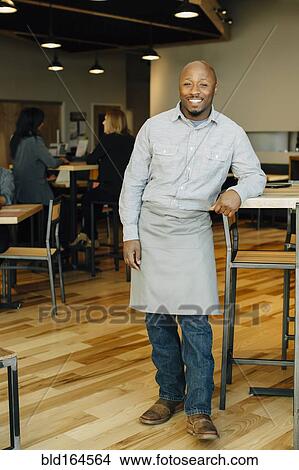 Picture - Black waiter smiling in in cafe. Fotosearch
