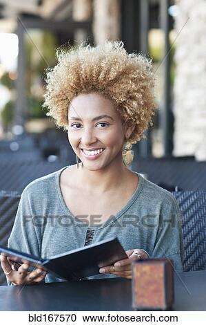 Black woman reading menu at cafe View Large Photo Image Stock Image - Black woman reading menu at cafe. Fotosearch