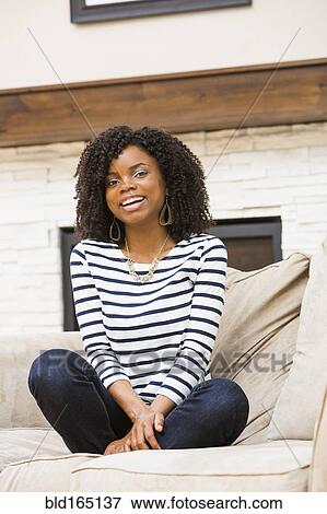 Black woman sitting cross-legged on sofa View Large Photo Image Stock Photo - Black woman sitting cross-legged on sofa. Fotosearch