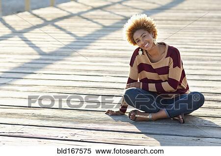 Black woman sitting on wooden boardwalk View Large Photo Image Stock Photography - Black woman sitting on wooden boardwalk. Fotosearch