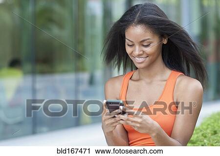 Black woman using cell phone outdoors View Large Photo Image Stock Image - Black woman using cell phone outdoors. Fotosearch