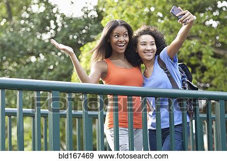 Black women taking selfie on walkway outdoors View Large Photo Image Stock Photo - Black women taking selfie on walkway outdoors. Fotosearch